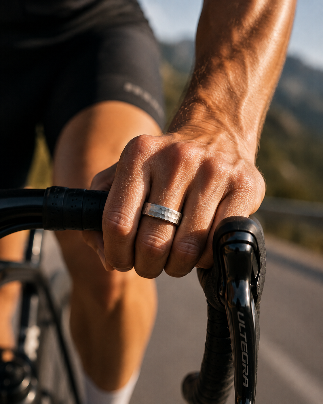 Hand mit dem SKELVIA Smart Ring in Hammerschlag-Optik am Lenker eines Rennrads