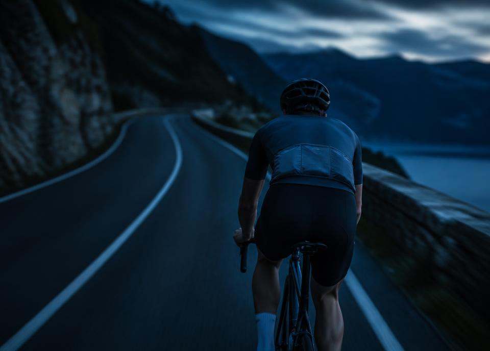 Radfahrer auf einer Bergstraße in der Dämmerung