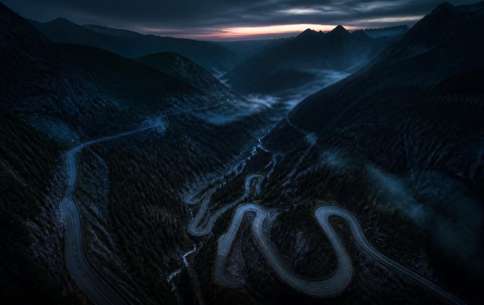 Luftbild einer kurvigen Bergstraße in der Dämmerung als Kartengrundlage
